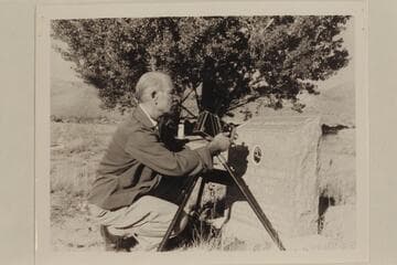 The gathering of river data. Photographing the photograph of Seymour Dubendorff on the headstone of his grave at Myton, Utah