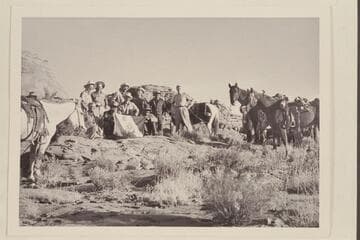The crew of the Land Cruise of 1955 in Little Finger Canyon, a side canyon of Navajo Canyon. Front: Ballard Atherton, Bahe, Masland, Whitehat. Standing: Marston, Cutler, Visbak, Daly, a Navajo boy of the Manygoats family, Desloge