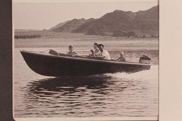 Jimmy Jordan at the controls of his Smith-Craft powered with Mercury motor.  The Jordan family takes the ride off Boulder City Beach