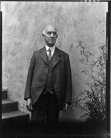 C. S. Hartman standing in courtyard at Grace Nicholson's Treasure House