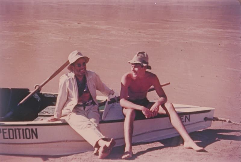 Photograph of two men sitting on a boat