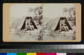 Two Hualapai Indians in front of a wooden shelter