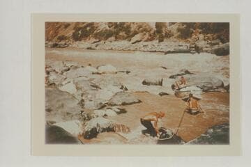 Lining the Nevills sadirons at Vulcan Rapid. Frost snubs the bow line. Nevills sits on the skiff. Desloge is in the water. Note lack of safety with Frost operating without a life preserver and the other two with the small inflated belts