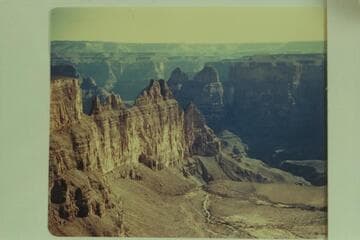 Lower end of Meriwitica looking down into Spencer Creek. Meriwitica Spring at lower extreme right. Meriwitica Cave shows plainly about middle of white wall just above the talus