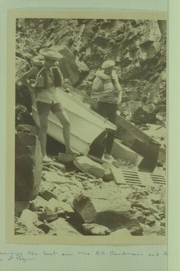 The wreck of the Harris-Brennan outboard below Hance Rapid. Examining the boat are Mrs. Bill Sanderson and Al Roueche, both of Page