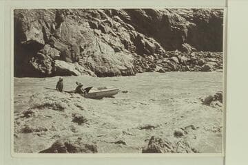 Del Reed at the oars and Bill Gibson riding at the foot of Grapevine Rapid. Nevills party of 1938. Bright Angel gauge: 19,800 cfs