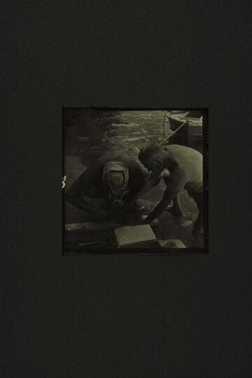 Repairing the CACTUS at the foot of Tuna Creek Rapid. Belknap and Taylor fashioning a patch