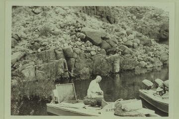 Lagoon at Tapeats Creek. Joe Desloge works at packing the "Rattlesnake"; Archeyes Masland in the "Bootoo"