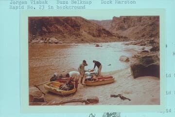 Loading Yaks at camp at Mile 202.25, right bank. Jorgen Visbak; Buzz Belknap; Dock Marston. Rapid No. 23 in background