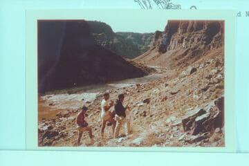 Photographing the Kolb inscription at the head of the talus at Mile 202.25. Buzz Belknap; Jorgen Visbak; Dock Marston. Rapid No. 23 in background at left