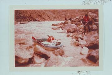 Dock Marston lines a boat at Dark Canyon Rapid. Jorgen Visbak and Buzz Belknap in distance