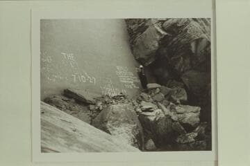 Norm Nevills painting his expedition sign on the wall in Cataract Canyon