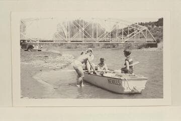 The start of the boat trip down the Dolores River. Dolores, Colorado. Pres Walker shoves the boat off from the shore. Left to right in boat: Marston, Margaret Marston, Becky Walker. Photo #2: left to right, boat in stream: See Note field