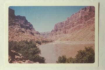 Down from approximately Mile 204.85 at head of One Mile Rapid from below a point opposite the mouth of Range Canyon. The button showing against the sky on right bank is at Mile 203