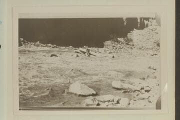 Salvage of rock-locked boat in Dark Canyon Rapid. USGS Cataract Canyon survey under W. R. Chenoweth. Copy of small print owned by Chenoweth. LaRue album No. 177. Print in Tasker album