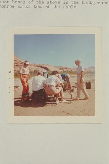 The wedding breakfast of Harry and Dorothy Aleson. Dorothy Aleson at left. Bishop Wells and Nina Robison have their back to the camera, Harry Aleson bend over stove in background and Barbara Monroe walks toward table