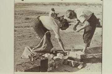 Anne Desloge and Zoe Desloge pack up at the camp at Pierces Ferry after the end of the 1947 Grand Canyon traverse. Margaret Marston is in the background