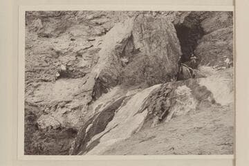 The travertine block at the mouth of Travertine Canyon. Ballard Atherton stands in the hole while Chuck Richey watches the stream from extreme right