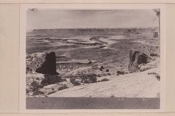 View southwest from Upheaval Dome--white rim sandstone edges the wide red Moenkopi bench. The Buttes of the Cross are upper right. Bonita Bend is center