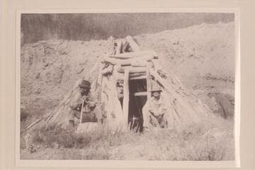 Abandoned hogan on the San Juan at mouth of canyon that is 10 miles by stream above the Colorado. Looking west. Bert Loper to right. Heber Christensen to left