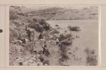 Camp below Mendenhall Loop where flood drove us out. Loper eating. Left to right: Christensen, Allen or Trimble, Miser, Hyde, Loper, Blake