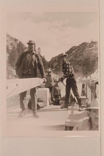 Don Smith at the forward sweep; Earl Kriley at the stern sweep. Glen Wooldridge stands by the outboard motor well. Keeler watches the operation