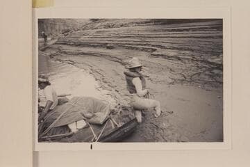 In Cataract Canyon Mile 186.5. Caption on the back of print reads: Kay Black leaps ashore at Mile 186.3 to 186.5 (4th camp from put-in at Potash plant on Colorado River near Moab). Needless to say she did not expect this