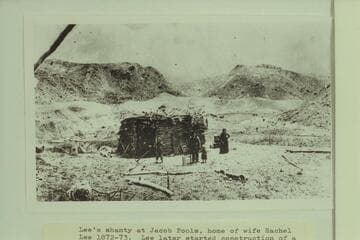 Lee's Shanty at Jacob Pools, home of wife Rachel Lee 1872-1873. Lee later started construction of a rock house at this location but it was never finished. People in photo probably J. D. and Rachel Lee