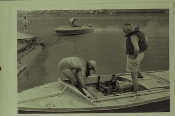 Preparation for the departure from Lees Ferry. Masland supervises the stowage by Marston. Cutler holds the bow line for Sanderson