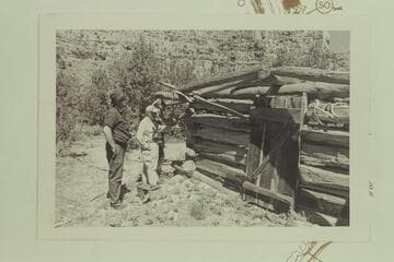 Chas. Peterson, Dock Marston and John Chaset examine the log cabin on the bar below the mouth of Chandler Creek