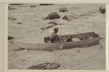 Lorin Bell in Government Rapid, San Juan River. 15-ft. folding spruce boat of the Monument Valley-Rainbow Bridge Expedition borrowed by Nevills