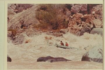 Buzz Belknap in the "Bootoo" clearing the big wave in Vulcan Rapid. Dock Marston is passenger