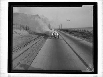 Auto racer driving "White Rocket" race car down coast highway, Santa Monica