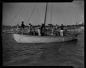 Group on a sailboat with the Santa Monica shore in the distance