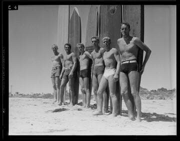 Men with surfboards posing on the beach, Santa Monica