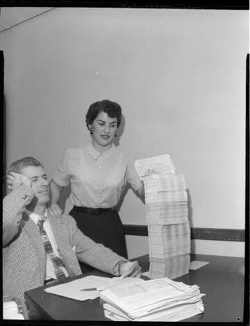 Office workers with key-punched computer data cards