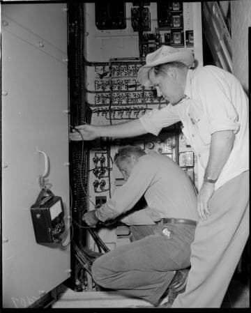 Electricians wiring a switchboard panel