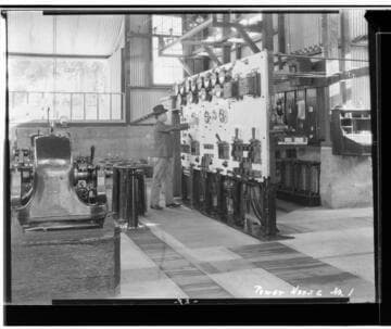 An interior view of Kaweah #1 Power House showing Operator Henry Heard operating the switchboard