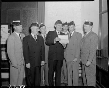 Men looking at document at meeting of American Legion, Eighteenth District