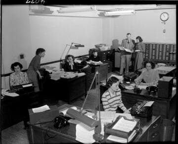 Young lady (new employee) being trained in office job at SCE