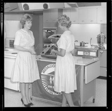 Women demonstrating Medallion Home electric cooking equipment at a promotional event