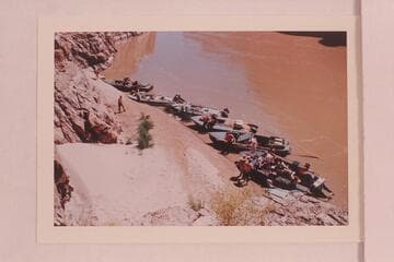 The seven boats of the Marston-Disney fleet moored below the skeleton above Paradise Canyon. Upper left is the "Emma Dean", the "Rattlesnake", the "Cactus", the "Paradox", the camera boat and the "Bootoo"