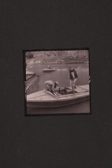 The boats used in the 1954, June traverse of Grand Canyon. Sanderson has fired up the motors of the "Rattlesnake" while Cutler holds the bow line. Marston is stowing the lines of the "BOOTOO" while Masland looks on