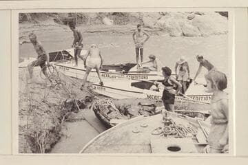 The combined Wright-Rigg parties landing at Spencer Creek, Mile 246. Elgin Pierce jumps ashore with the painter of the inflated boat while Georgie White watches